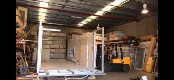 A forklift moves building materials inside a warehouse.