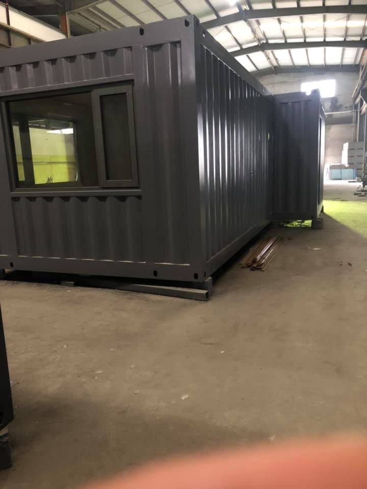 Gray shipping container with window in a warehouse.