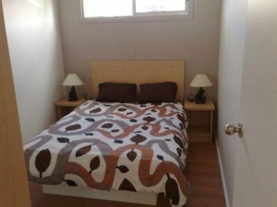 Bedroom with a double bed, two nightstands, two lamps, and a small window.