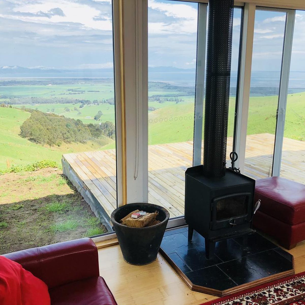 A cozy room with a wood stove and a scenic outdoor view.