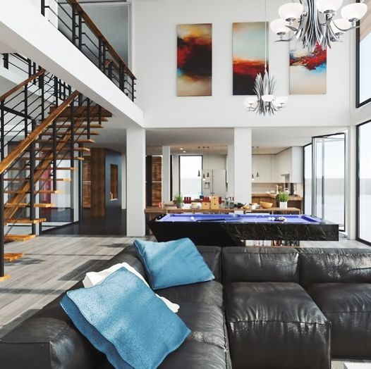 Living room with black leather couch, pool table, and art; open to kitchen and second floor.