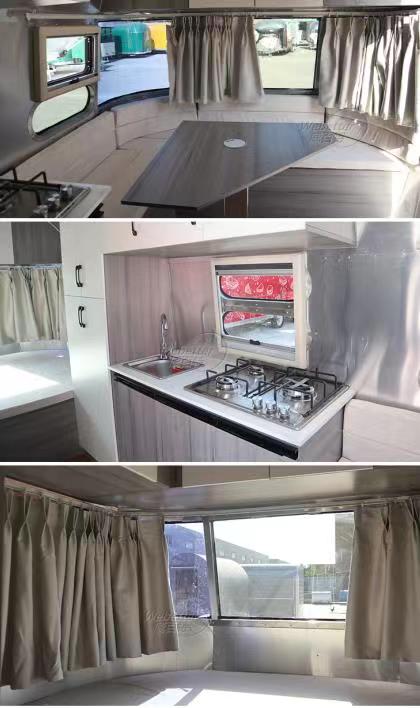 Interior views of a modern camper with stainless steel and light wood finishes, featuring kitchen, table, and windows with curtains.