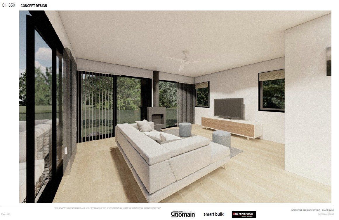 Modern living room with light-colored sofa, fireplace, and large windows overlooking greenery.