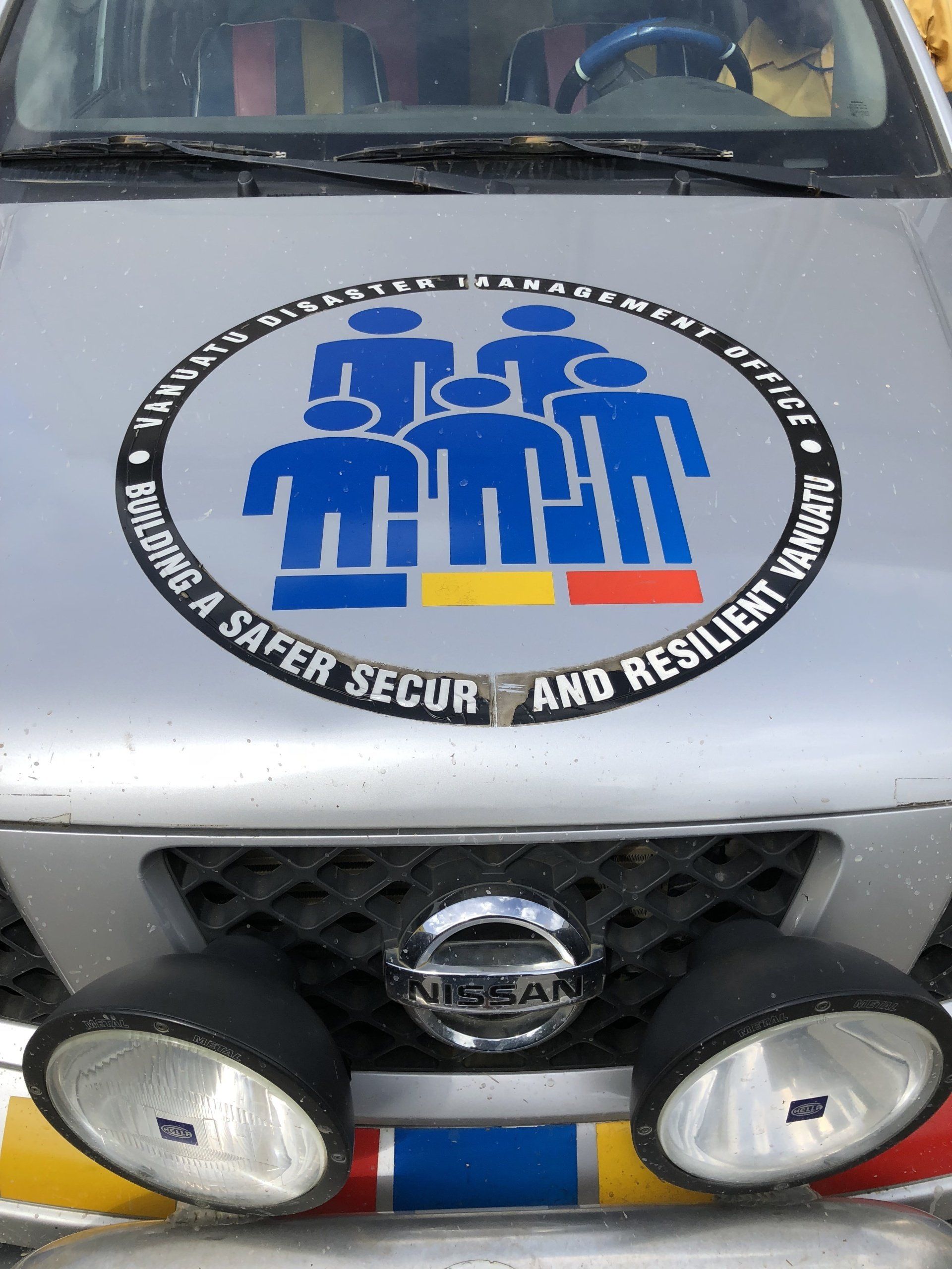 Silver vehicle with logo: blue stick figures, text 