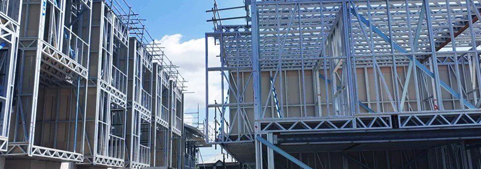 Construction site with steel framing against a blue sky.