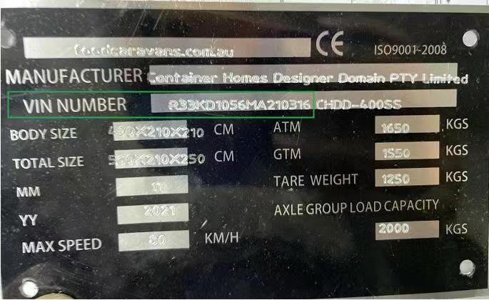 A metal plate with details of a container, including manufacturer, VIN, body size, and weight capacities.