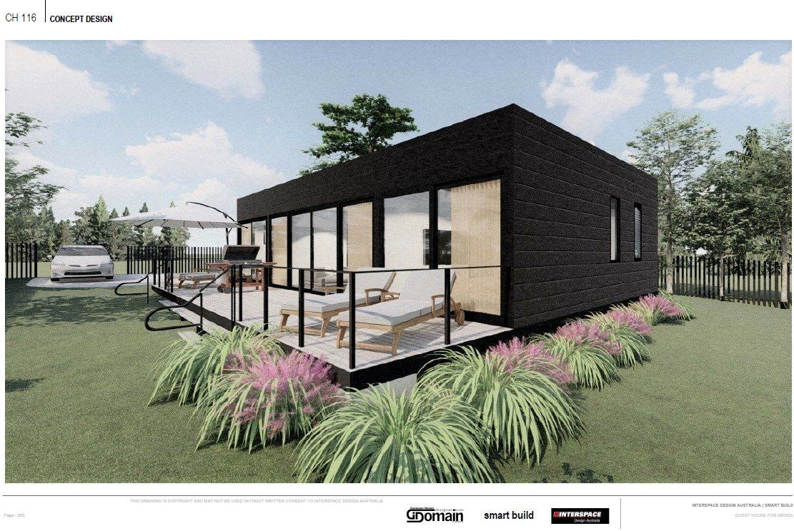 Modern black house with glass walls and a deck, surrounded by grass and landscaping.