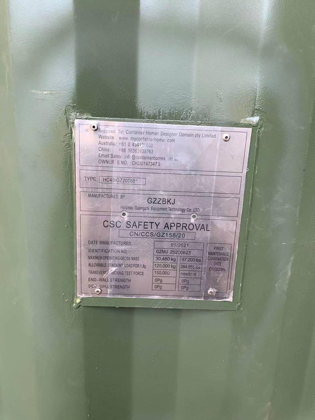 Metal plate on a green surface with stamped information, 