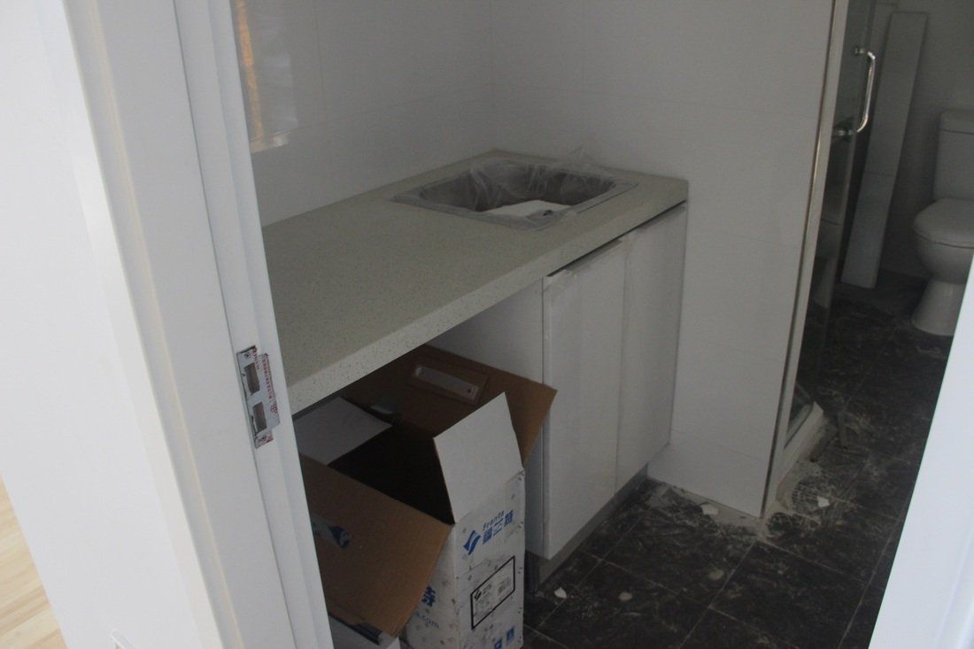 Small bathroom with sink and cabinet, cardboard box in foreground.