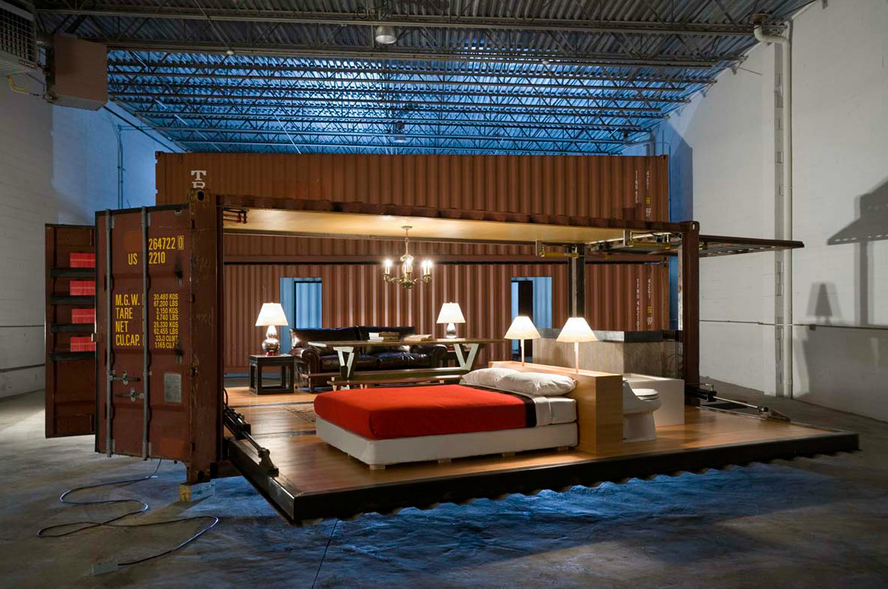 Shipping container home with opened walls displaying living space, brown and red tones.