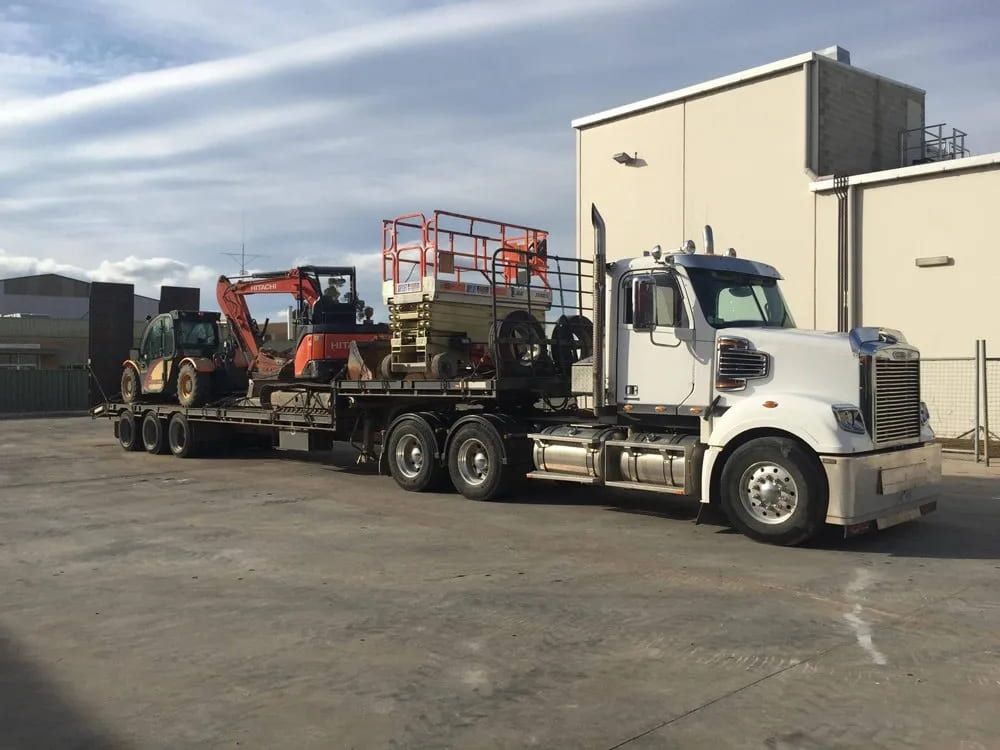 A Semi Truck Is Carrying a Forklift on A Flatbed Trailer — Albury Demolitions in Lavington, NSW