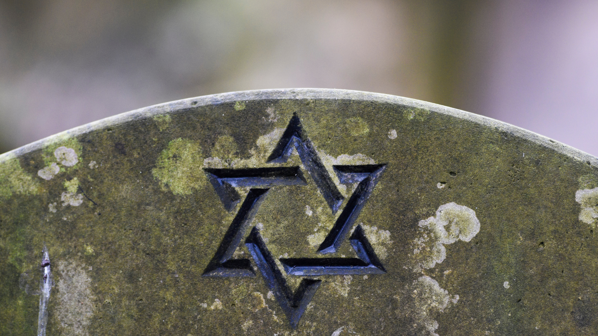 A close up of a gravestone with a star carved into it.