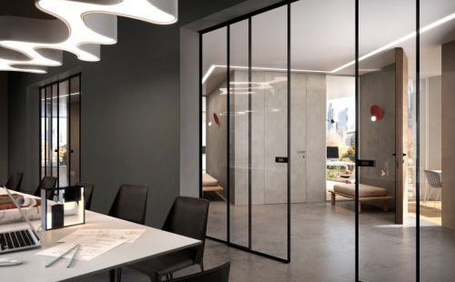 Interno di un ufficio moderno con porte con pannelli in vetro, pareti grigie e un tavolo da conferenza.