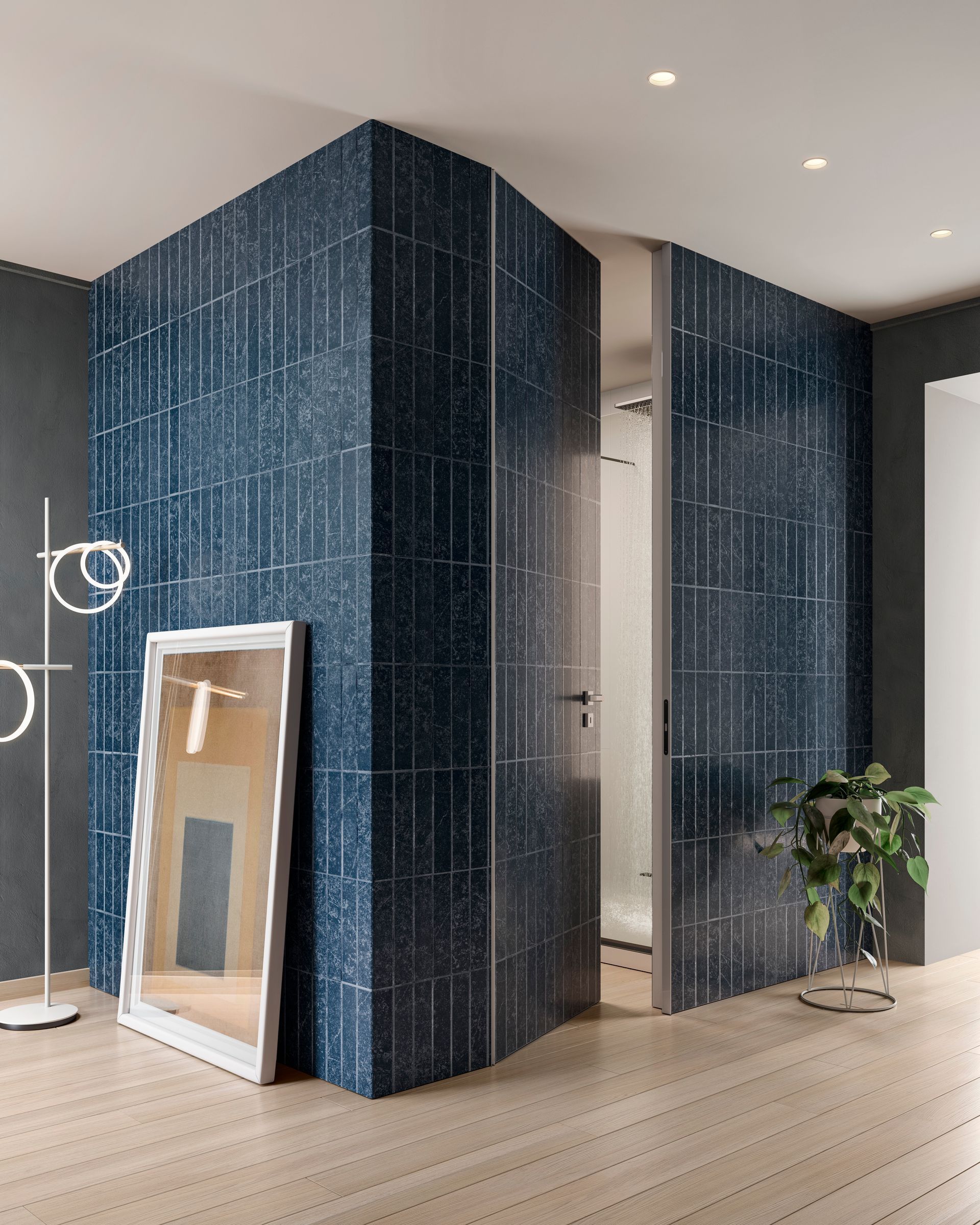 Pareti del bagno piastrellate di blu, con specchio e pianta da appartamento. Pavimento in legno chiaro.