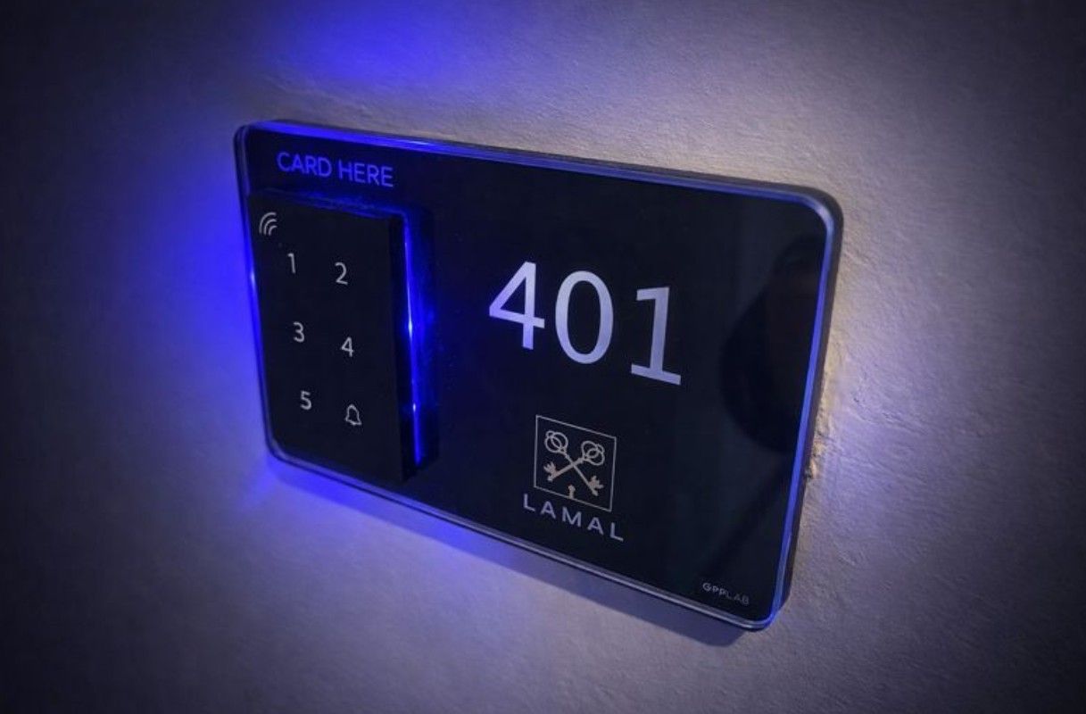 Pannello della porta della camera d'albergo con numero di camera 401, lettore di schede, tastiera e illuminazione blu.