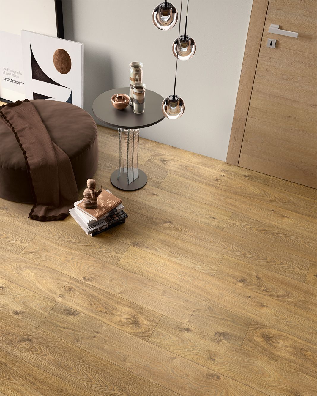 Pavimento in legno in una stanza con tavolo rotondo, pouf, opere d'arte e luci sospese.