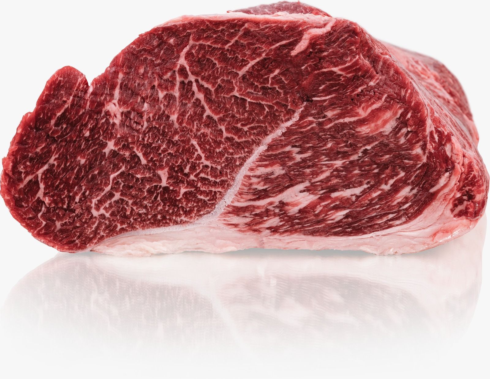 Ein Stück rohes Rindfleisch liegt auf einer weißen Oberfläche.