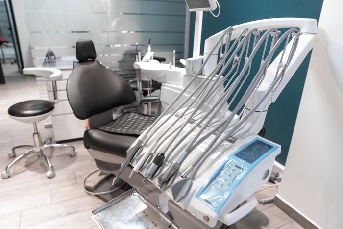 Modern dental office with exam chair, equipment, and tools on a counter