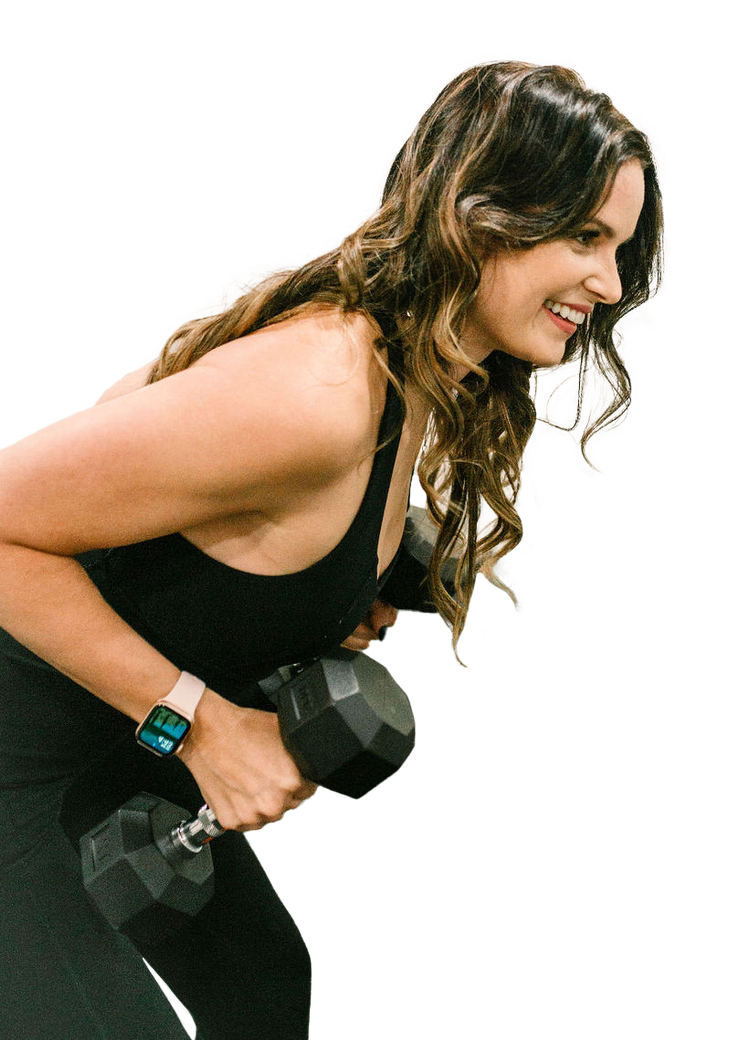 A woman in a black tank top is holding a dumbbell and smiling.