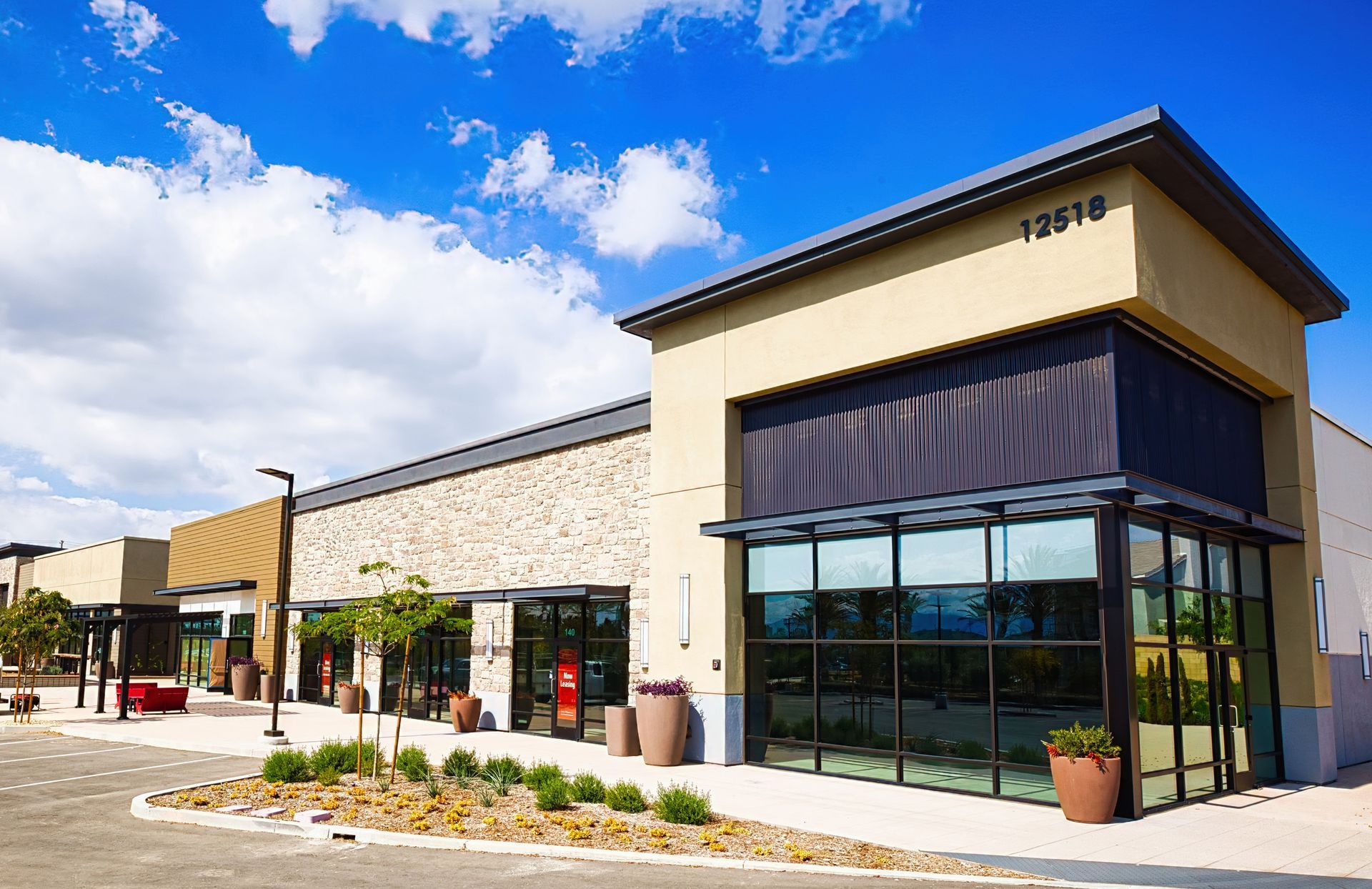 A modern, single-story retail building with a tan stone facade.