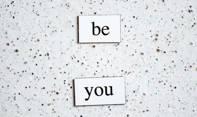 White speckled background with cut outs of words be and you