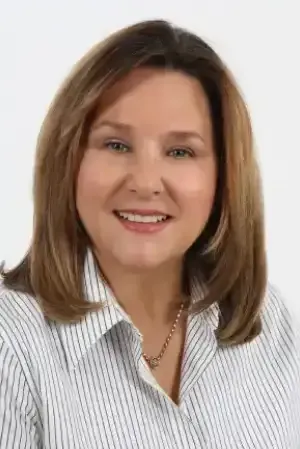 Smiling woman in a white striped blouse against a plain light background