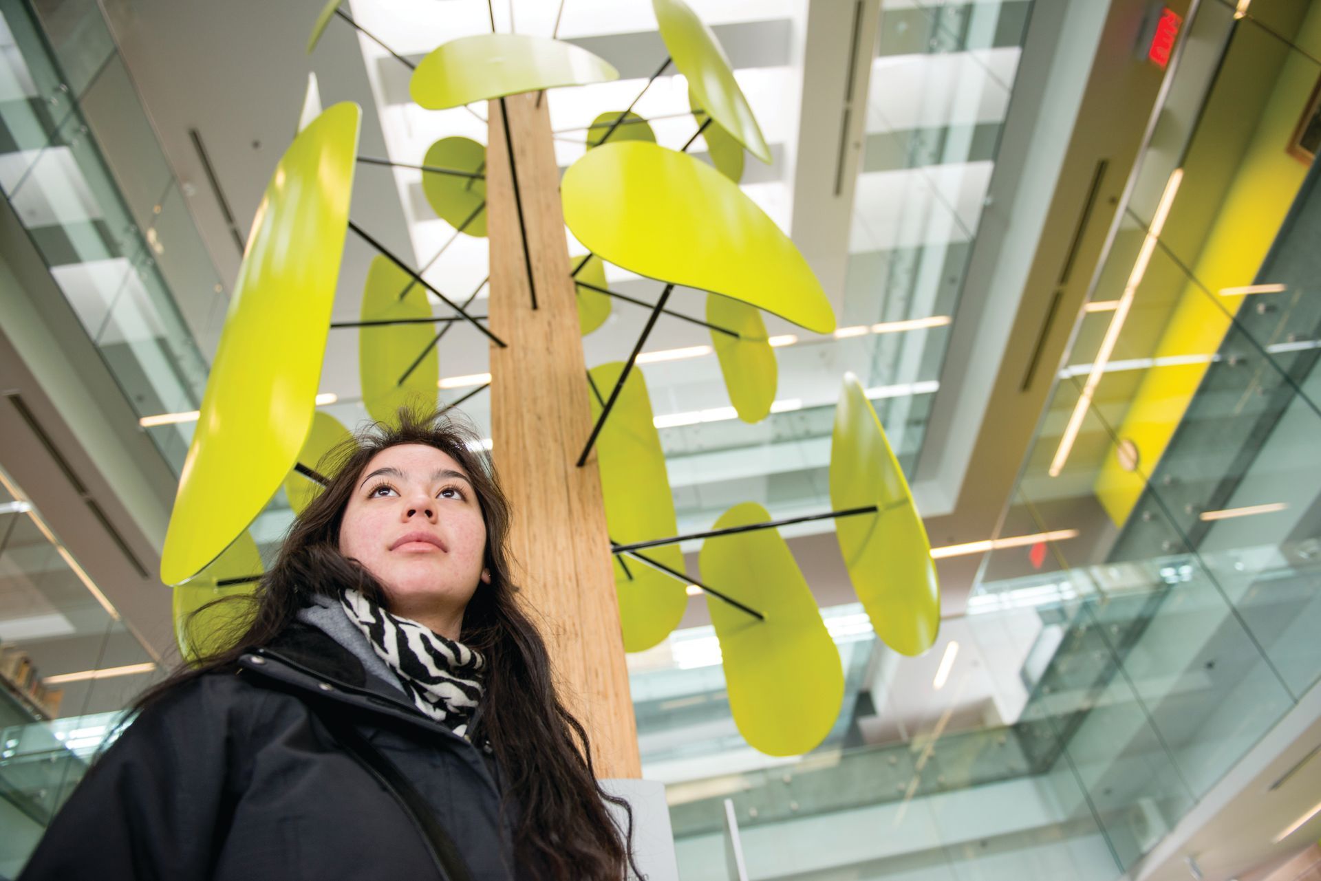 a woman looks up at a sculpture in a building