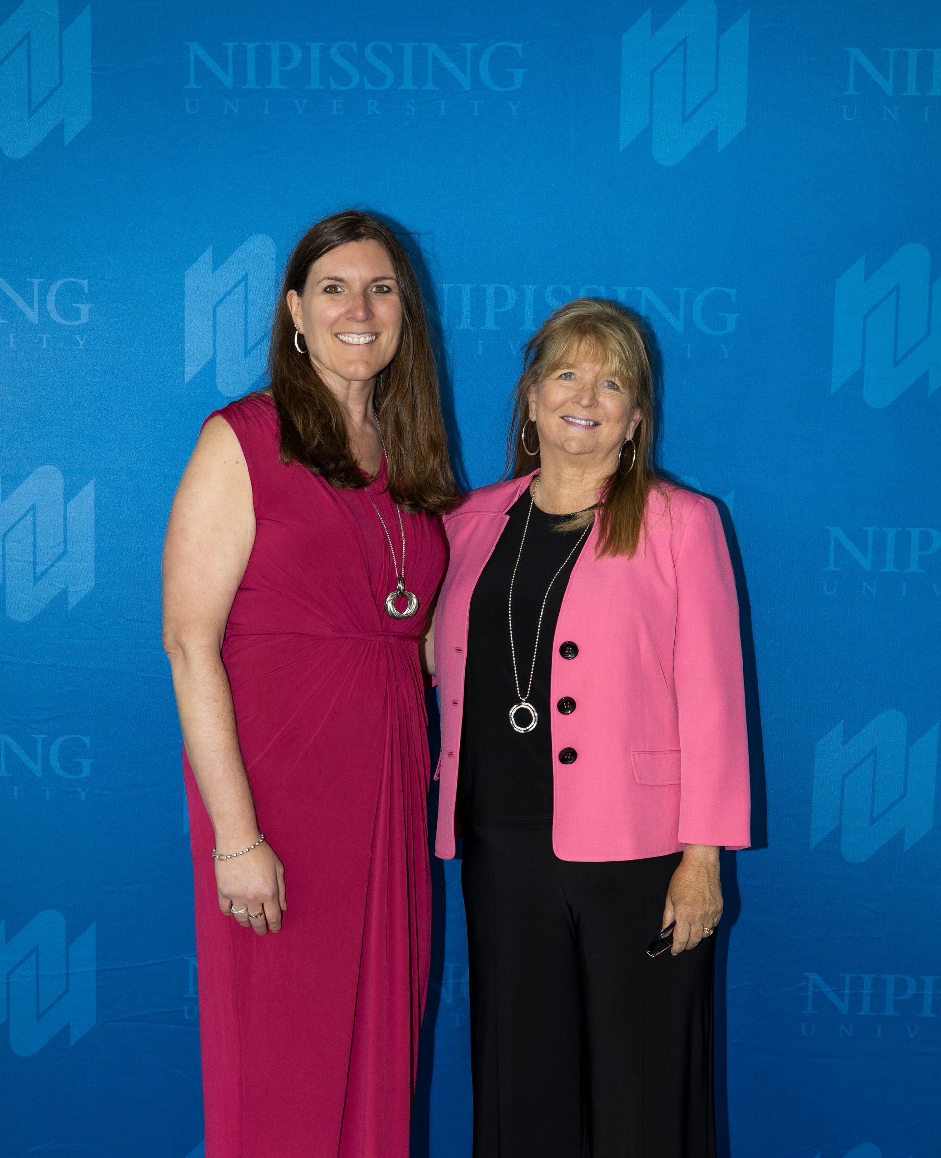 Evening at Nipissing 2026 attendees smiling against Nipissing University backdrop 
