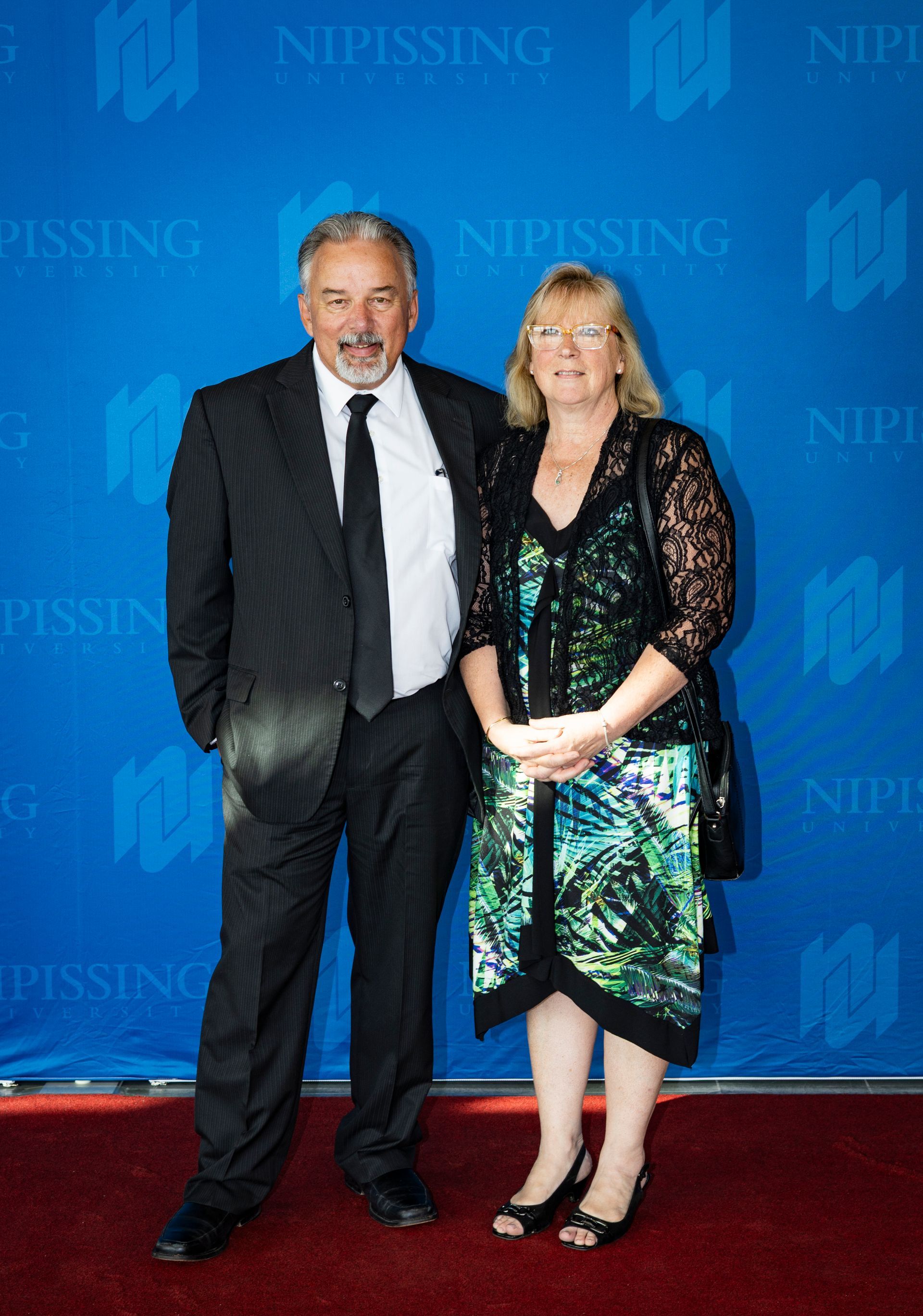 Evening at Nipissing 2026 attendees smiling against Nipissing University backdrop 