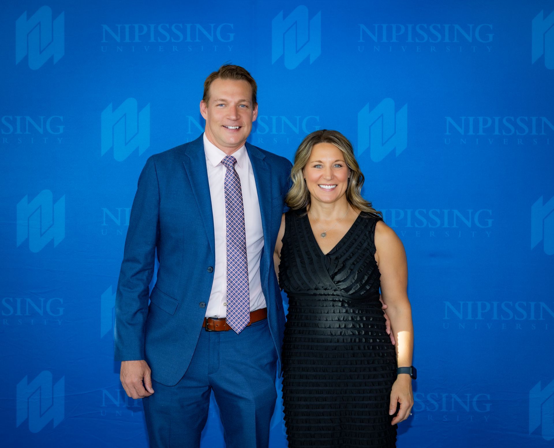 Evening at Nipissing 2026 attendees smiling against Nipissing University backdrop 