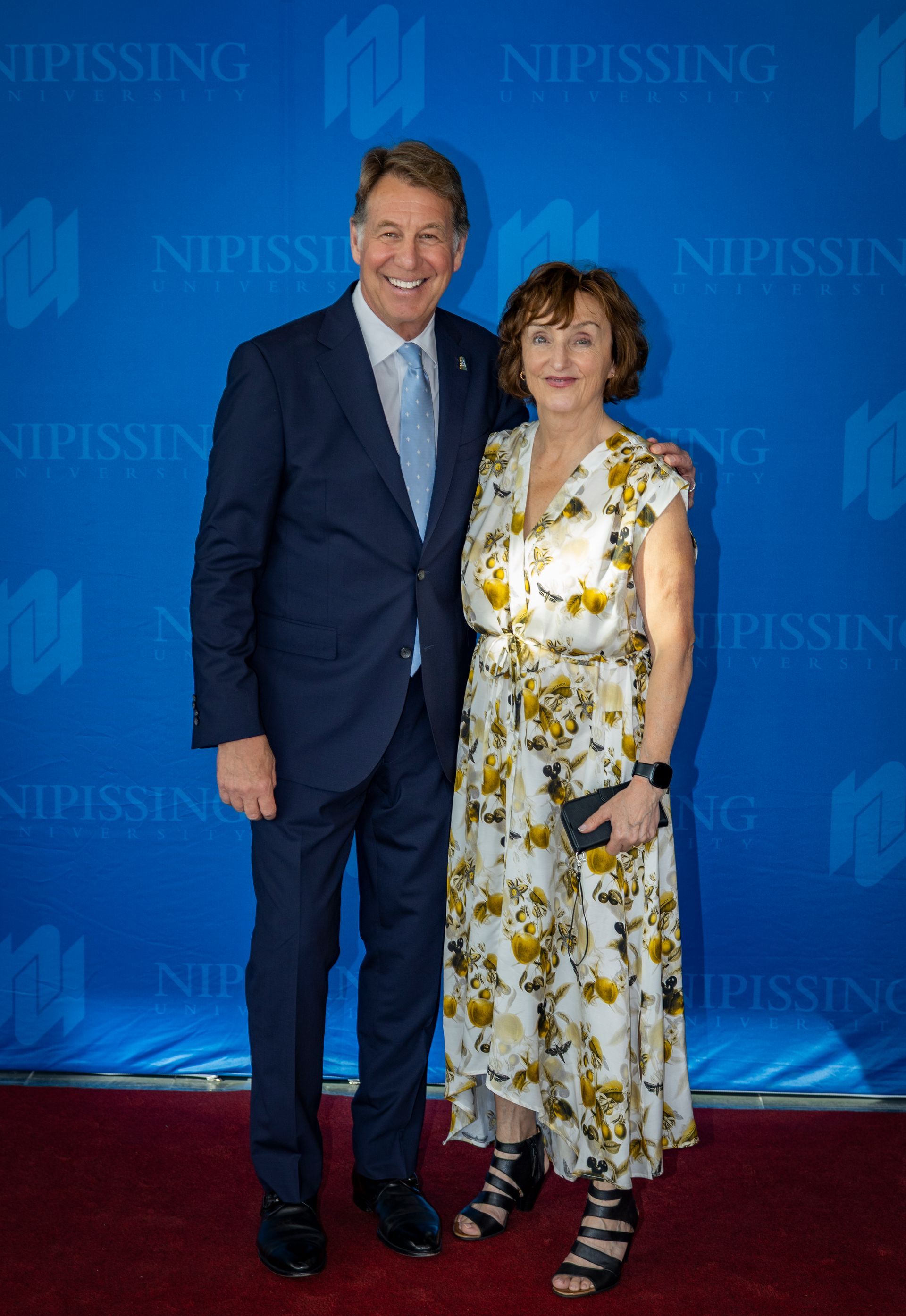 Evening at Nipissing 2026 attendees smiling against Nipissing University backdrop 