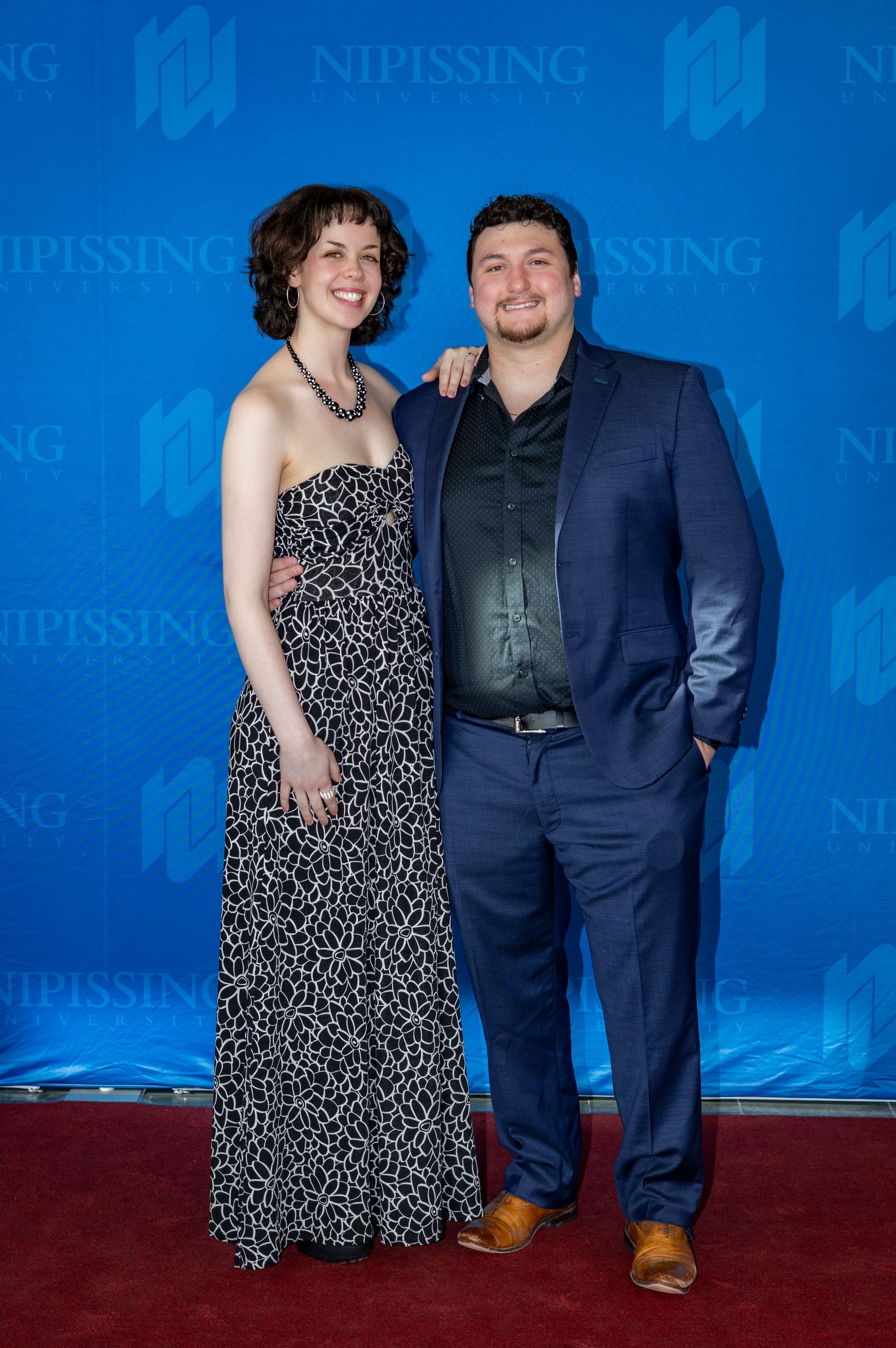 Evening at Nipissing 2026 attendees smiling against Nipissing University backdrop 