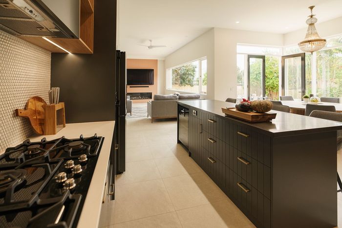 A kitchen with a large island in the middle and a stove top oven.