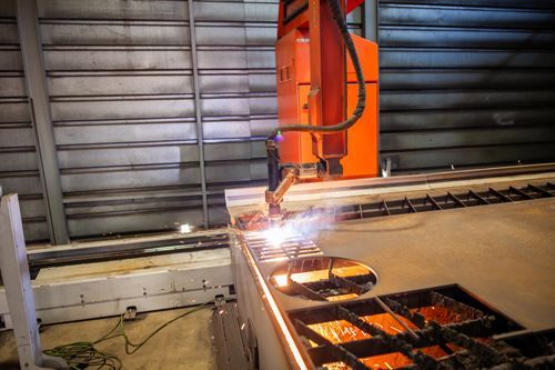A machine is cutting a piece of metal in a factory.