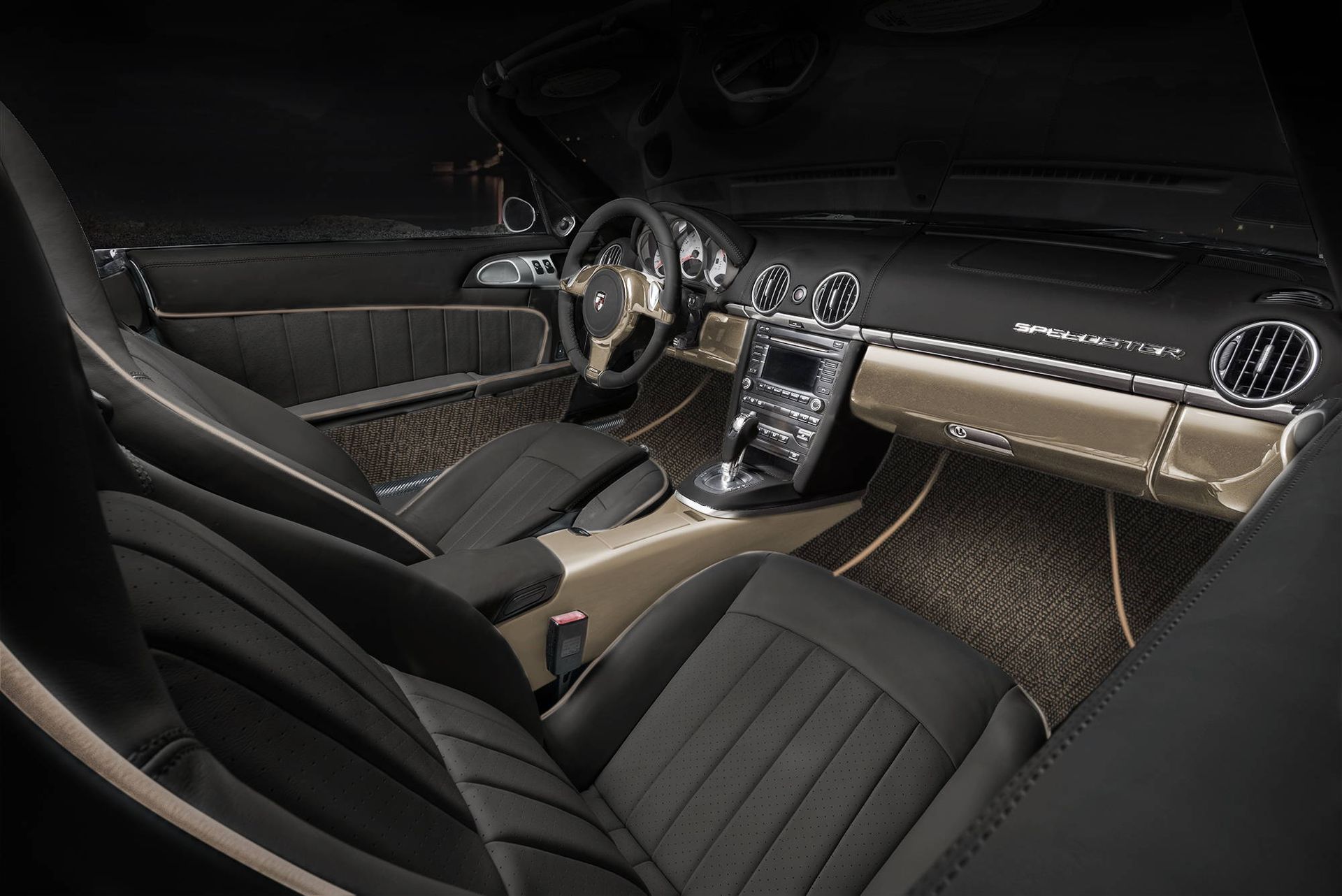 Luxurious black car interior with tan dashboard, quilted seats, and illuminated center console.