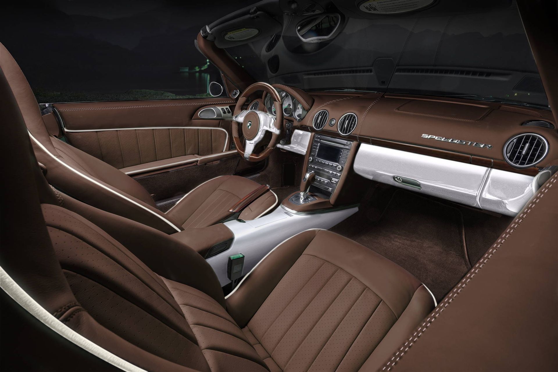 Luxury car interior with brown leather seats, silver dashboard, and wood-trim steering wheel