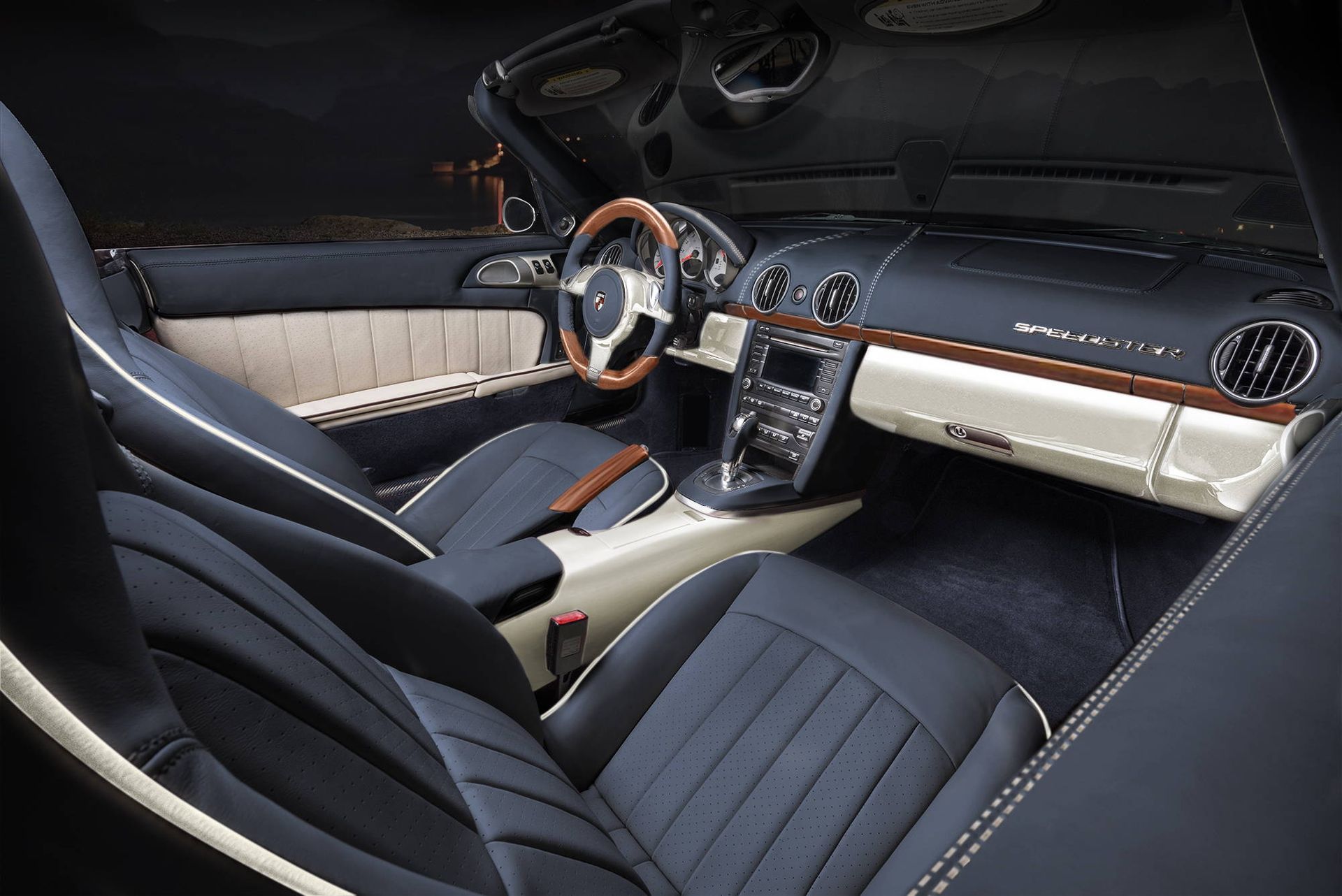 Luxury car interior with black leather seats, wood accents, and a dashboard viewed from the passenger side
