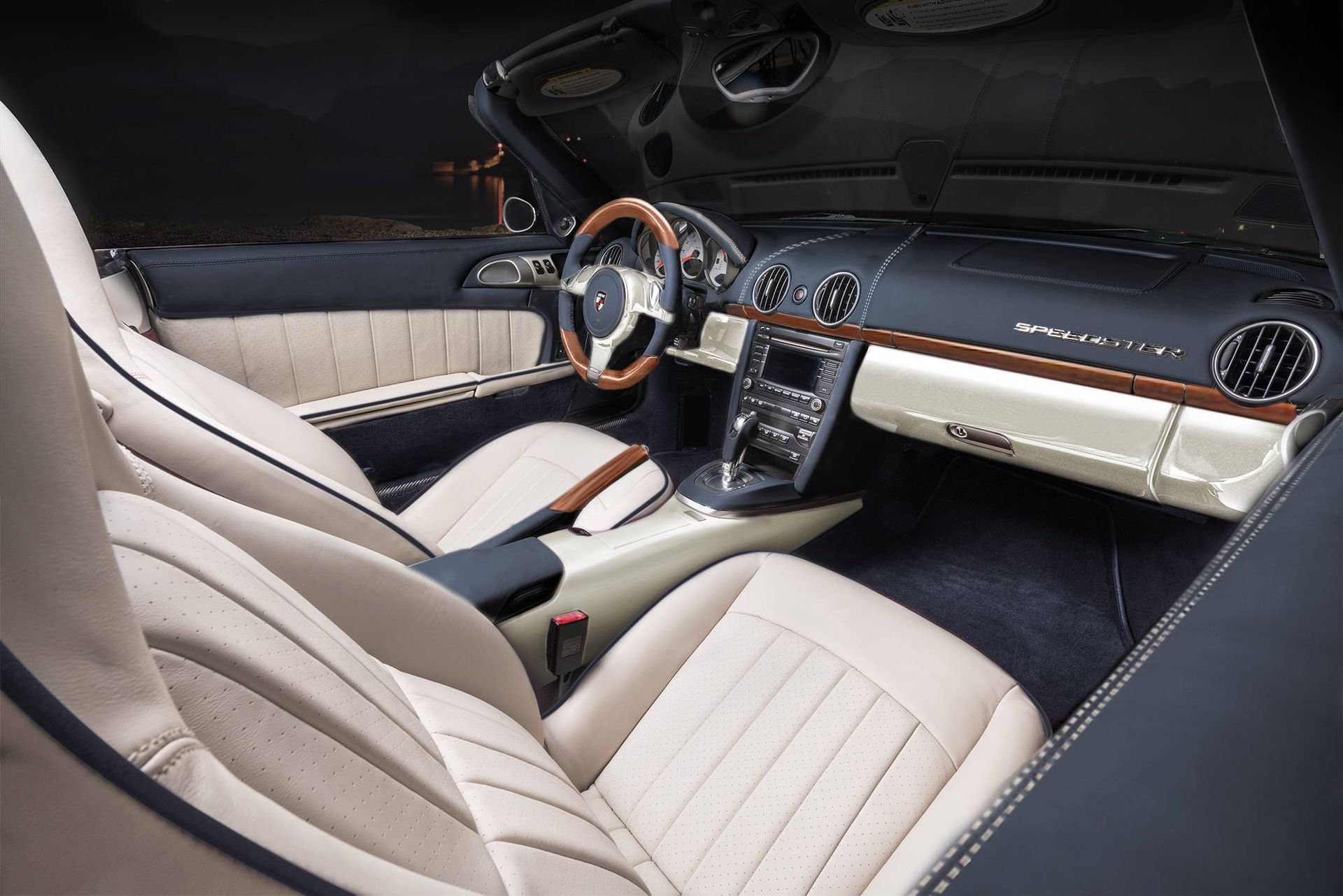 Luxury car interior with tan leather seats, wood steering wheel, and black dashboard view