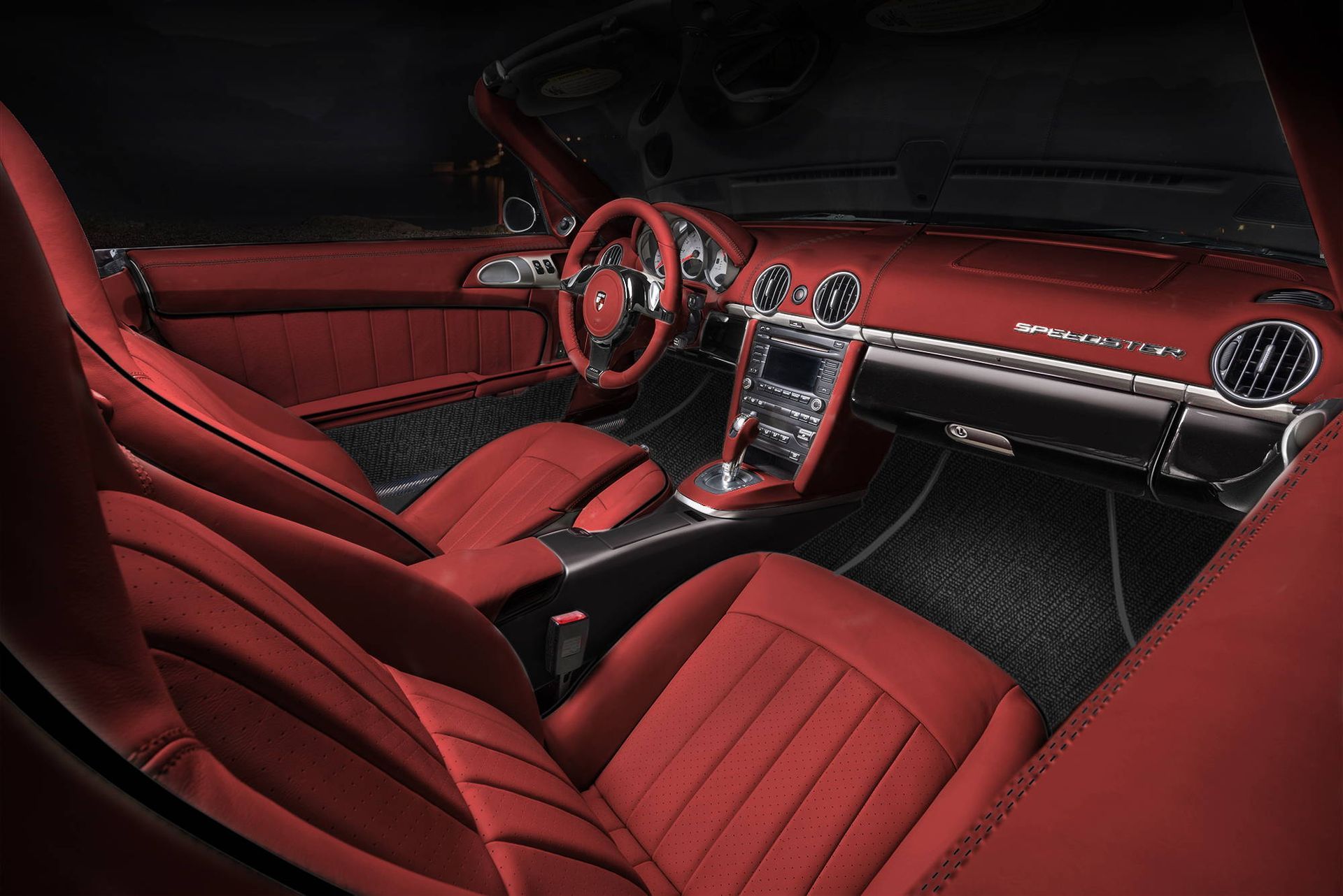 Red luxury car interior with red leather seats, dashboard, and center console at night
