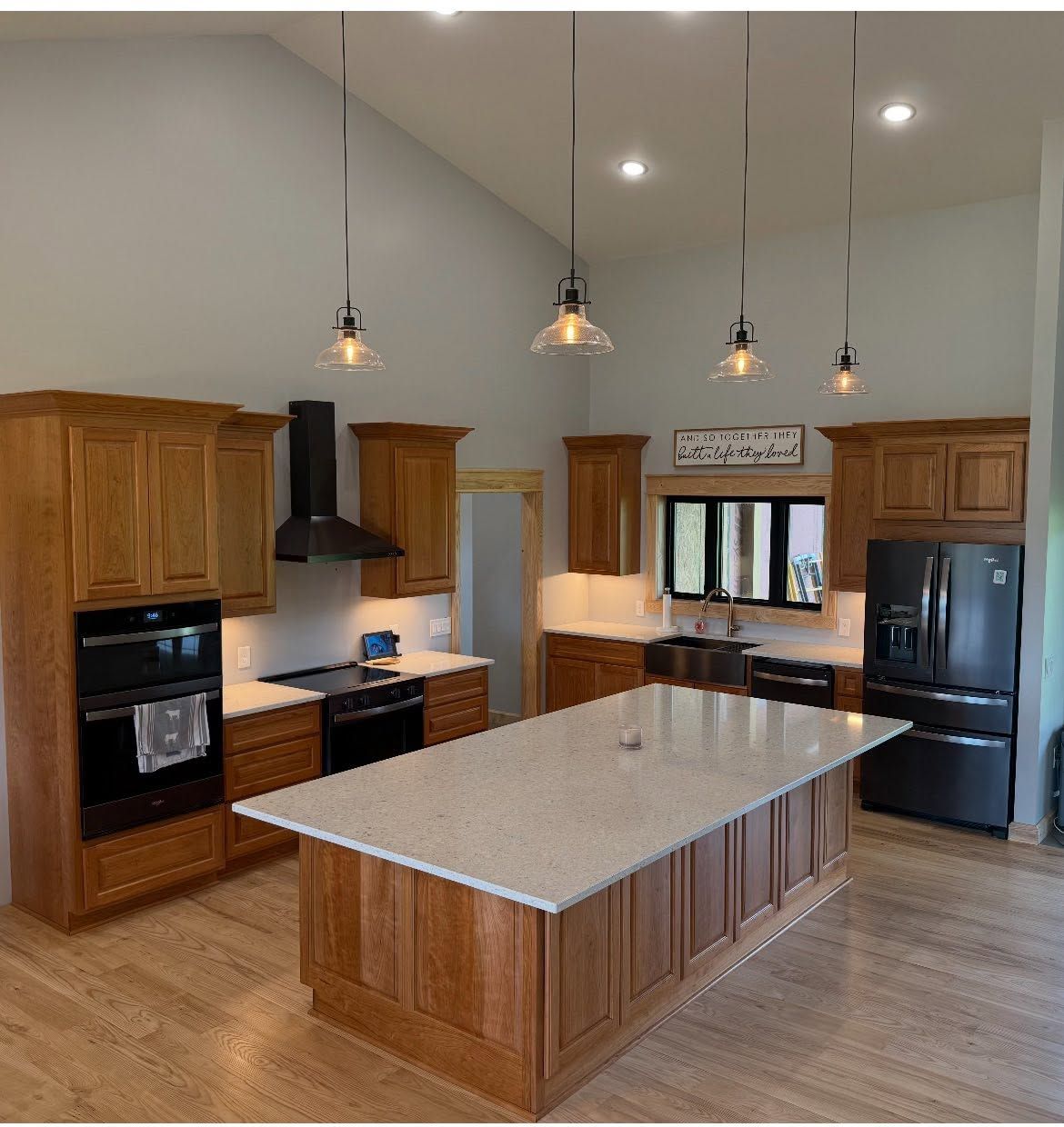 Modern kitchen with wood cabinets, large island, stainless appliances, and pendant lights