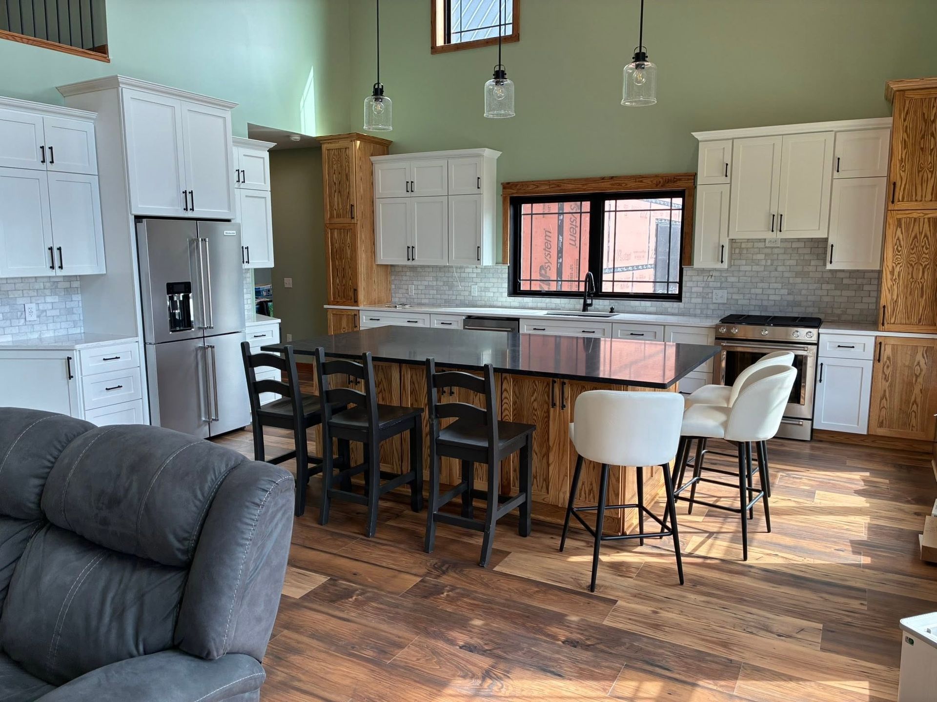 Open-plan kitchen and living room with white cabinets, wood floors, and a dining table by the island.