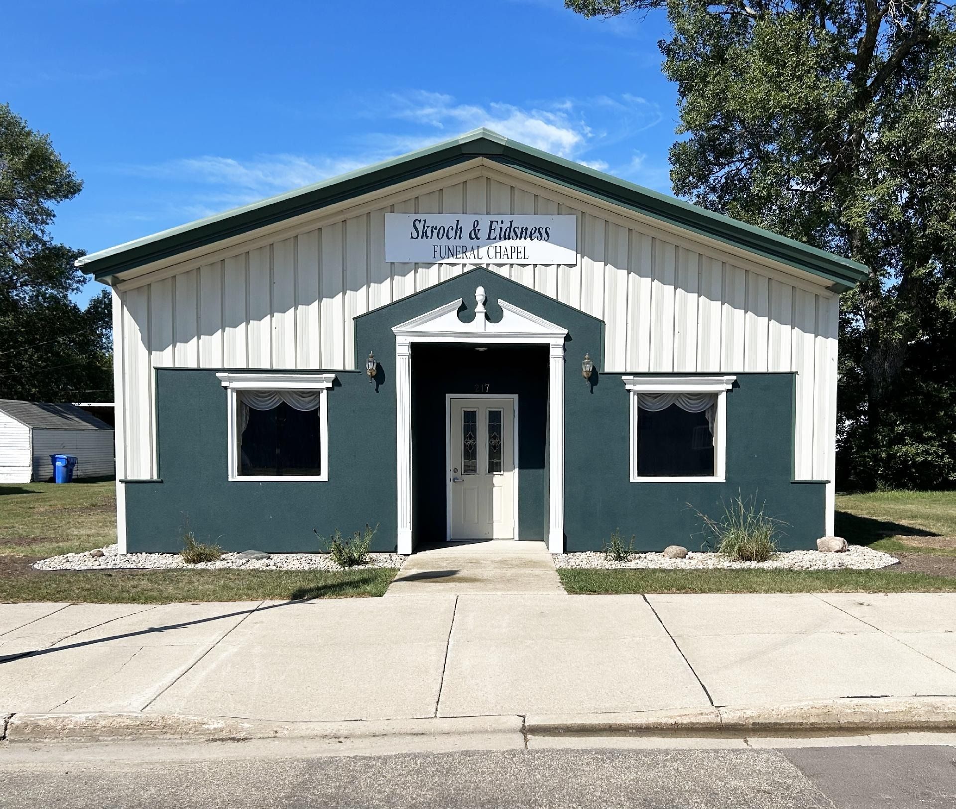 Tan building with blue shingle roof,