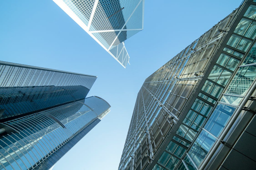 Skyscrapers against a bright blue sky, angled upward. Reflective glass facades.