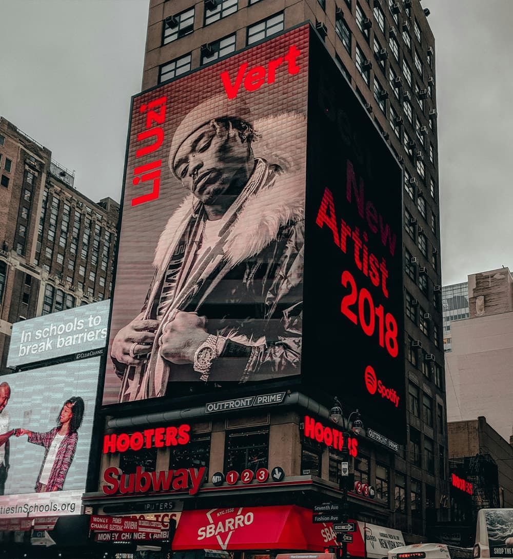 Gran cartel en Nueva York con la foto iluminada de un hombre y la frase 
