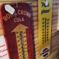 Vintage drink thermometers for Royal Crown Cola and Pepsi hanging side by side.