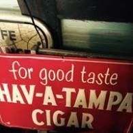 Red Hav-A-Tampa Cigar sign with white lettering and the slogan “for good taste.”