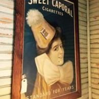 Vintage Sweet Caporal cigarettes poster featuring a woman in a yellow hat and white ruff.