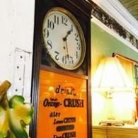 Vintage wall clock above orange poster and lit table lamp in a cozy interior