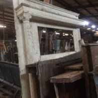 Dusty old wooden cabinet in a warehouse, with a large glass panel and worn paint