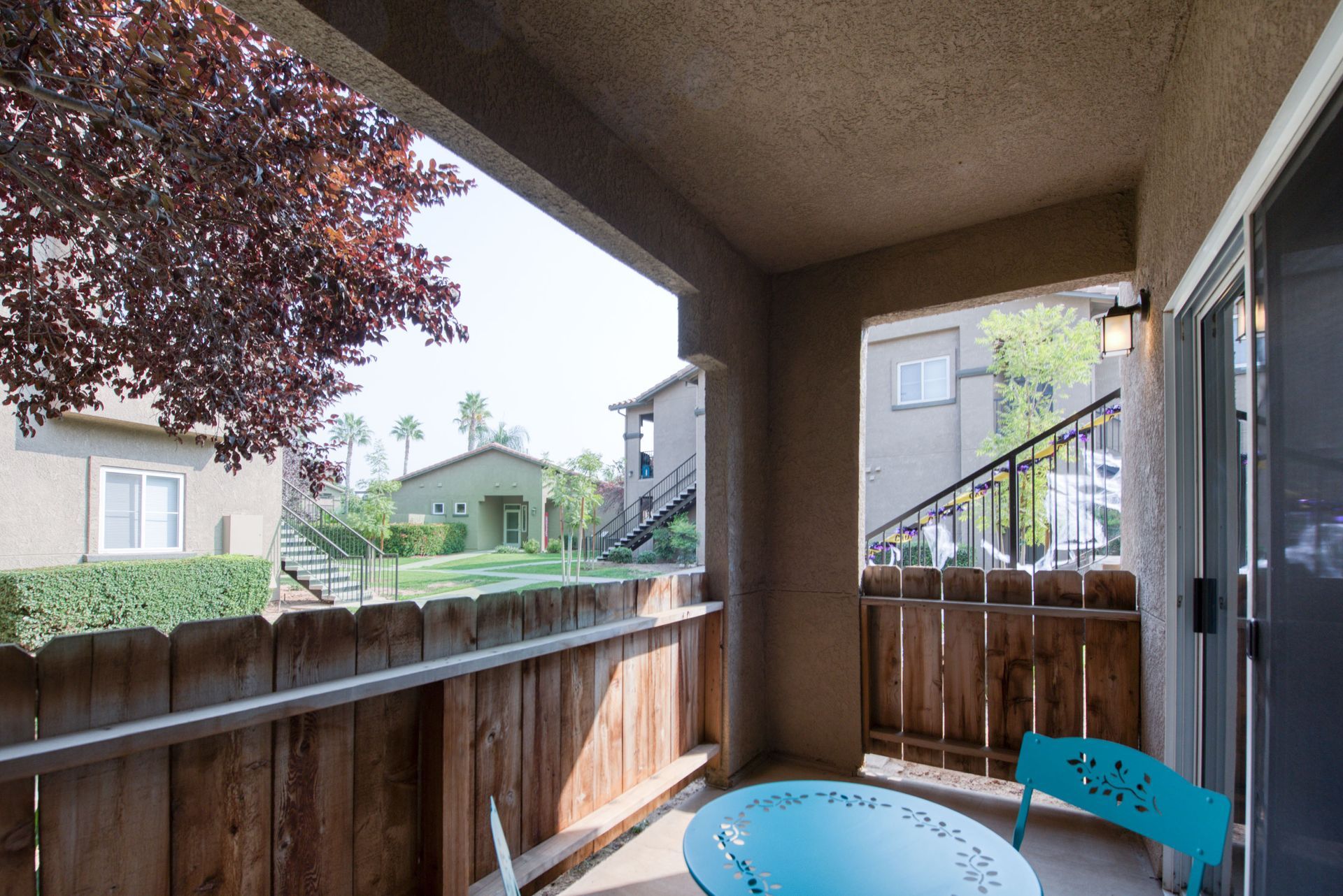 a balcony with a table and chairs and a sliding glass door .